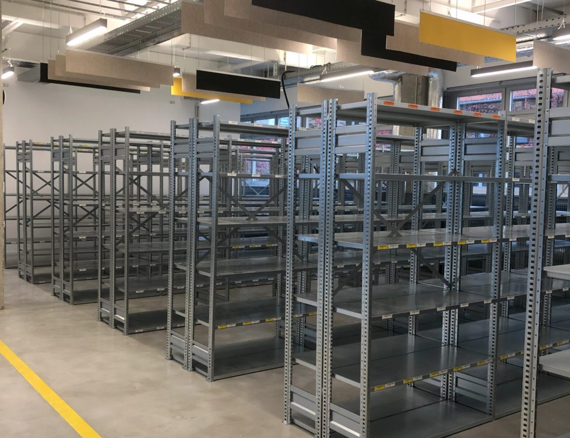 Instalacja regałów magazynowych z widocznym systemem oznaczeń podłogowych i elementami sufitowymi