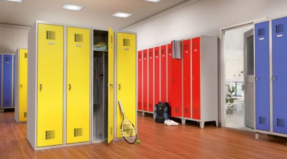 Szafki szatniowe metalowe - wielokolorowe wyposażenie szatni sportowej Szatnia z metalowymi szafkami w kolorach żółtym, czerwonym i niebieskim na drewnianej podłodze