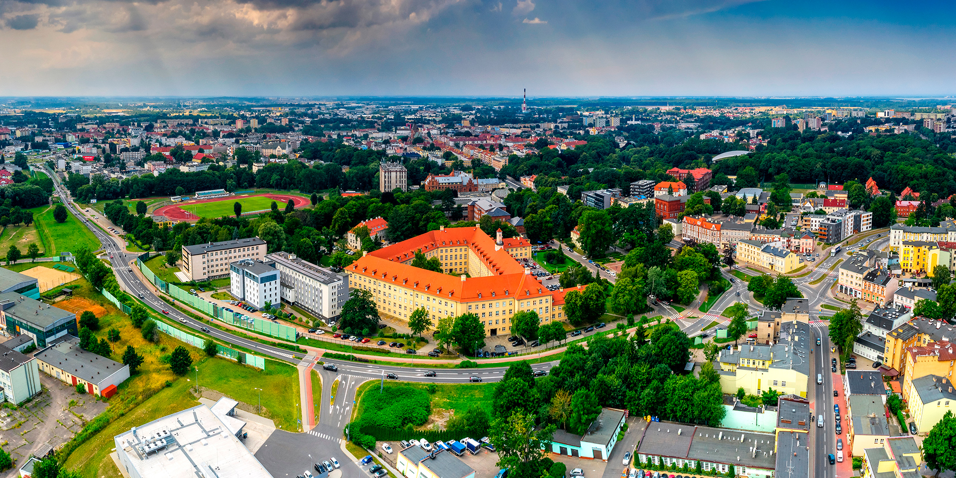 Panorama Koszalina z lotu ptaka, widok na zabytkowy budynek i zieleń miejską. Regały Magazynowe Koszalin